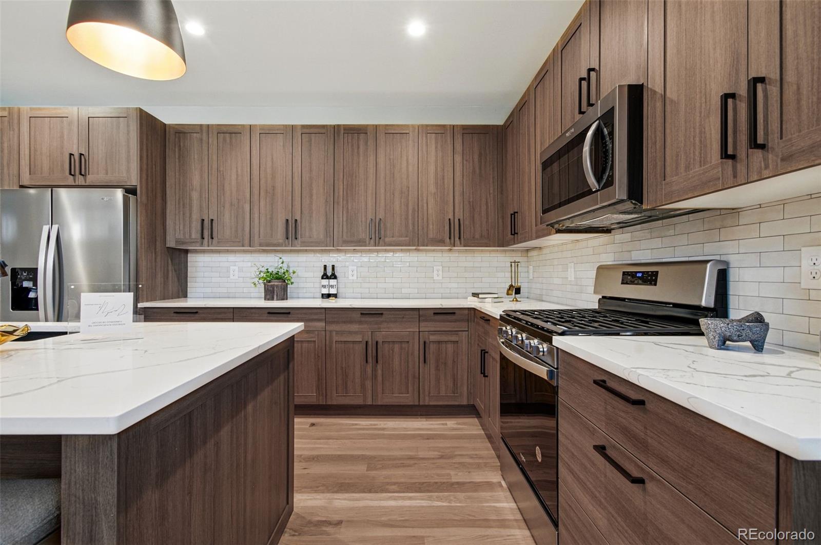 4121 Tejon Street Denver, CO 80211 - Photo 17 of 38 a kitchen with stainless steel appliances a sink a stove a refrigerator cabinets and a counter top space