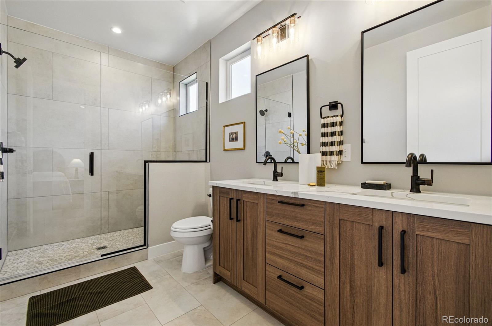 4121 Tejon Street Denver, CO 80211 - Photo 23 of 38 a bathroom with a double vanity sink toilet and shower