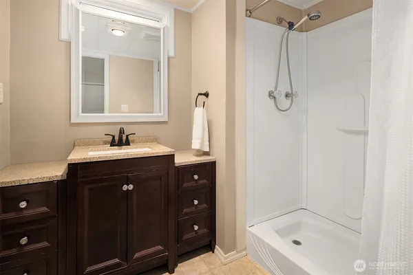 a bathroom with a tub sink vanity and mirror