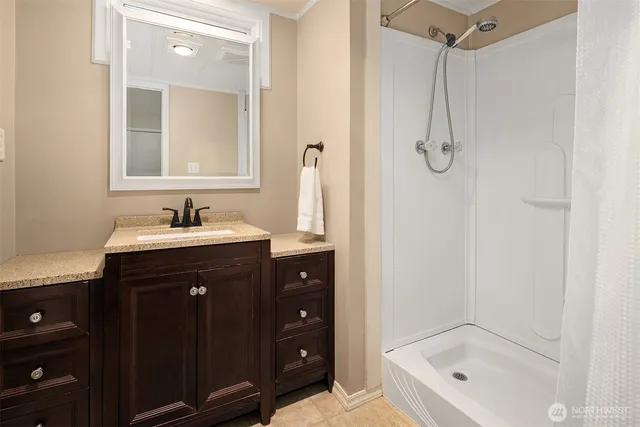 a bathroom with a tub sink vanity and mirror