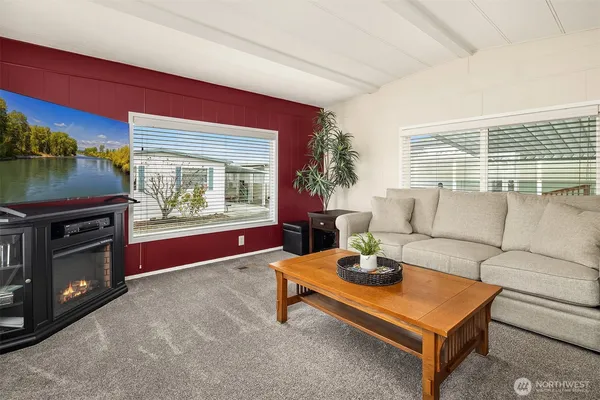 a living room with furniture a flat screen tv and a fireplace