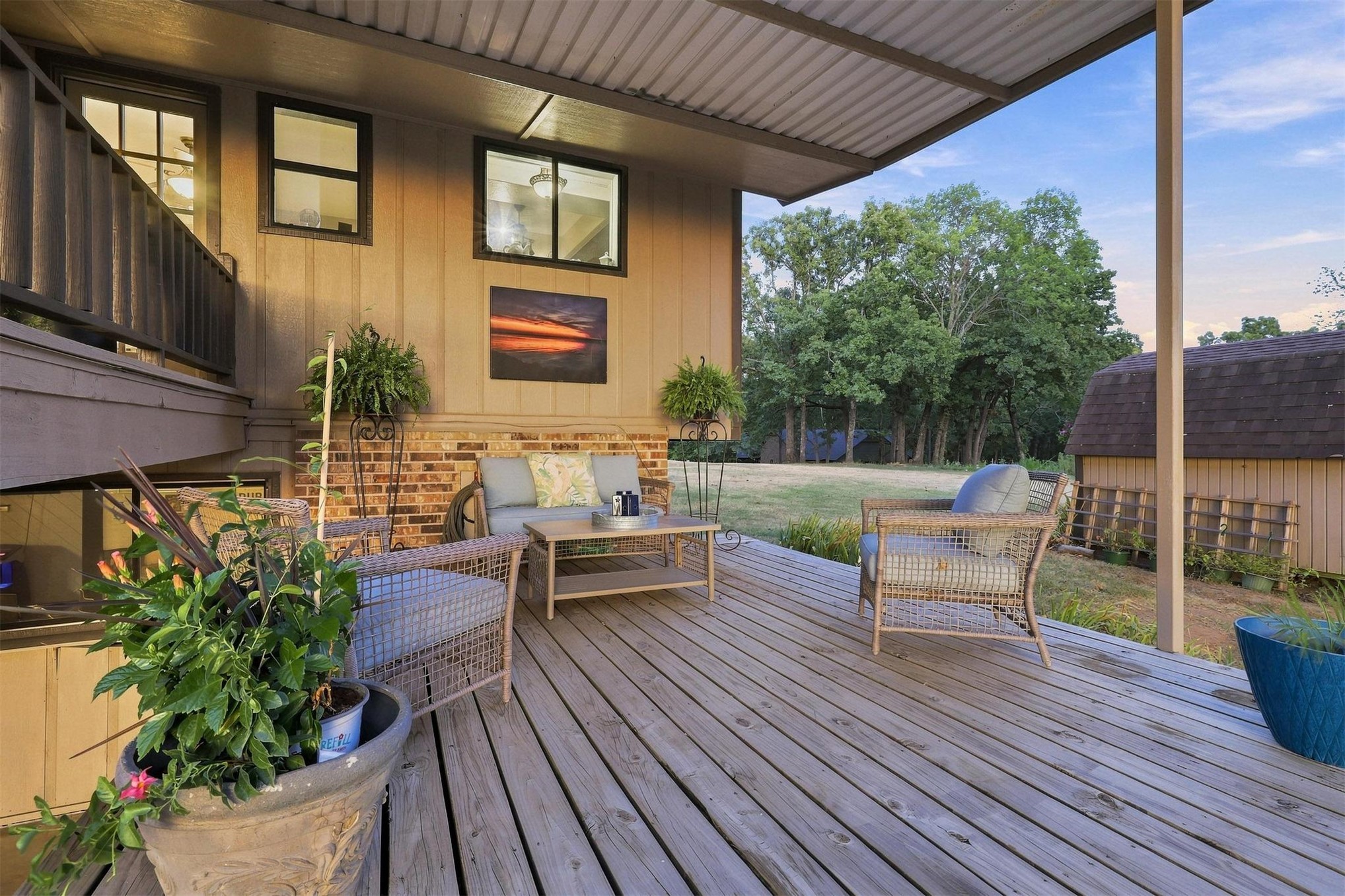 171 Woods Road Mead, OK 73449 - Photo 55 of 62 Expansive outdoor deck with a corrugated metal roof, wood-finish decking, and brick accent wall