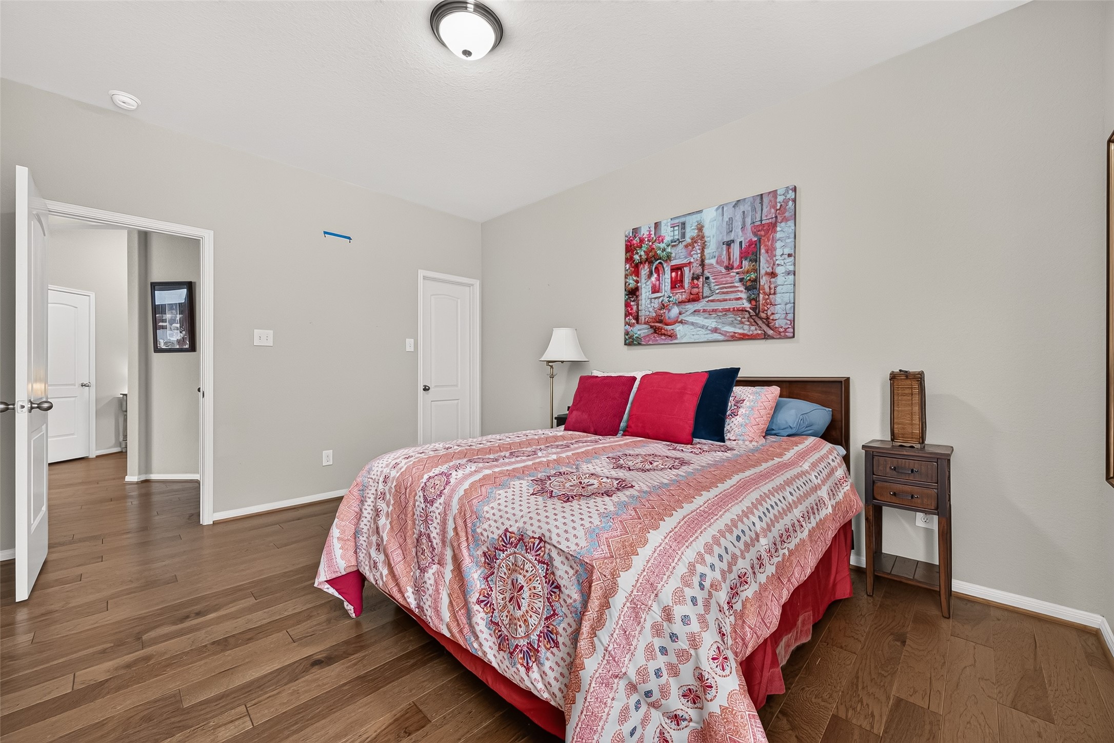 4910 Culver Lane Rosenberg, TX 77471 - Photo 39 of 50 Second bedroom with hardwood floors, neutral walls, and ample natural light. Two doors lead to additional rooms, enhancing accessibility and flow.