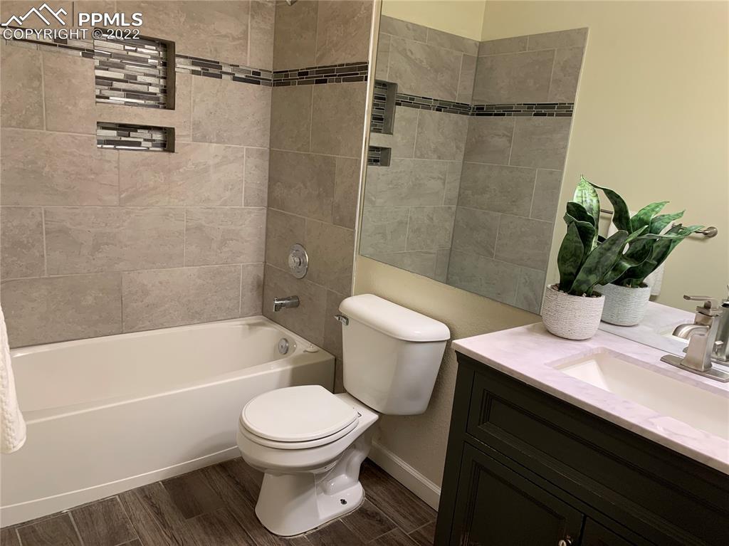 924 Samuel Point Colorado Springs, CO 80906 - Photo 14 of 22 a bathroom with a sink a toilet a mirror and shower