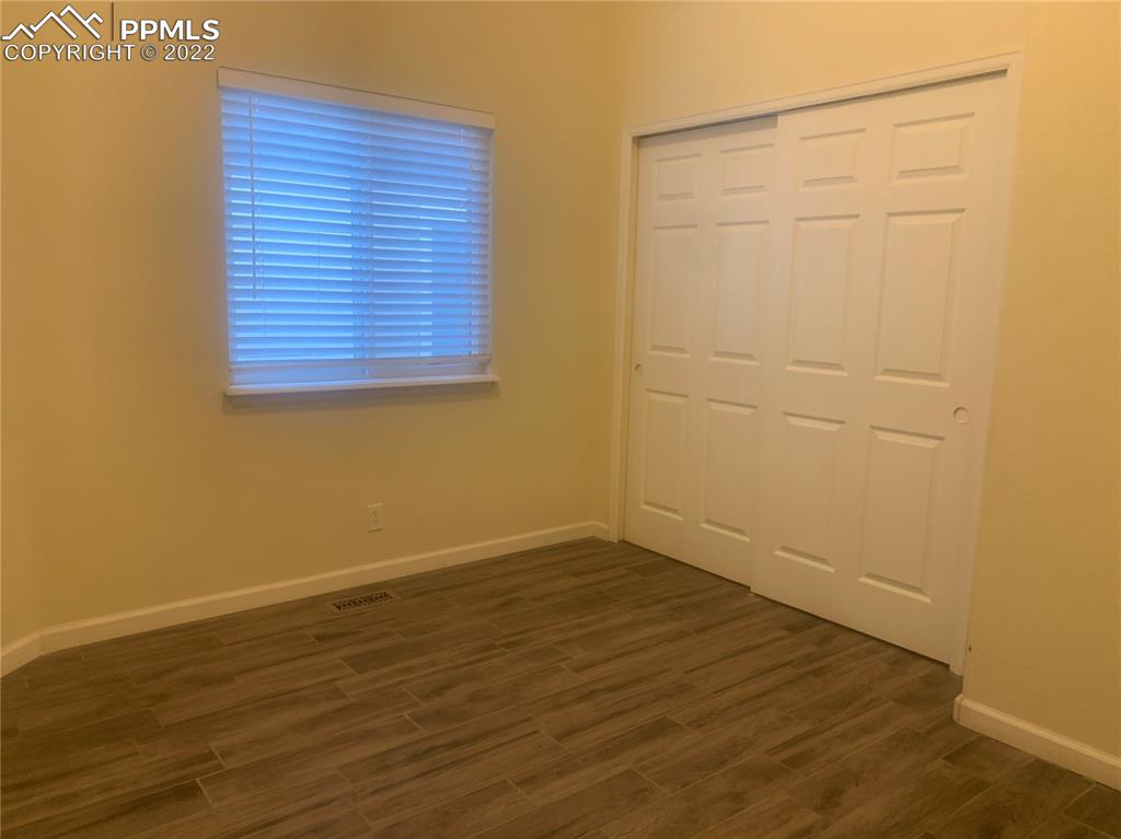 924 Samuel Point Colorado Springs, CO 80906 - Photo 5 of 22 an empty room with wooden floor and cabinets