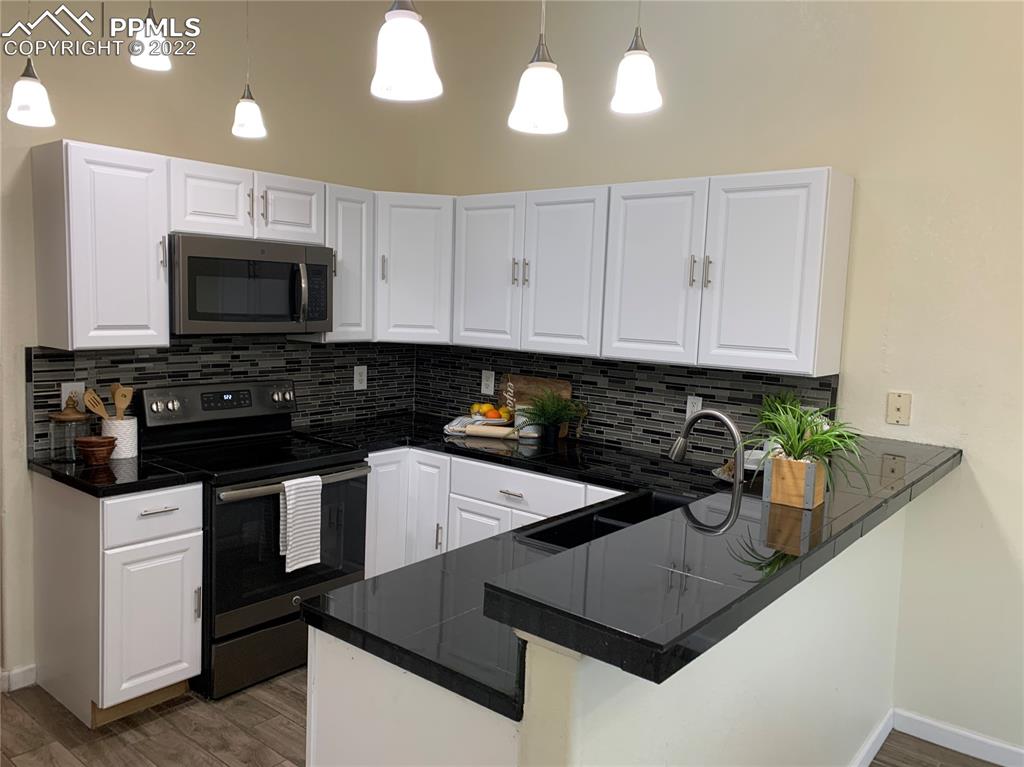 924 Samuel Point Colorado Springs, CO 80906 - Photo 9 of 22 a kitchen with stainless steel appliances granite countertop a sink stove and microwave