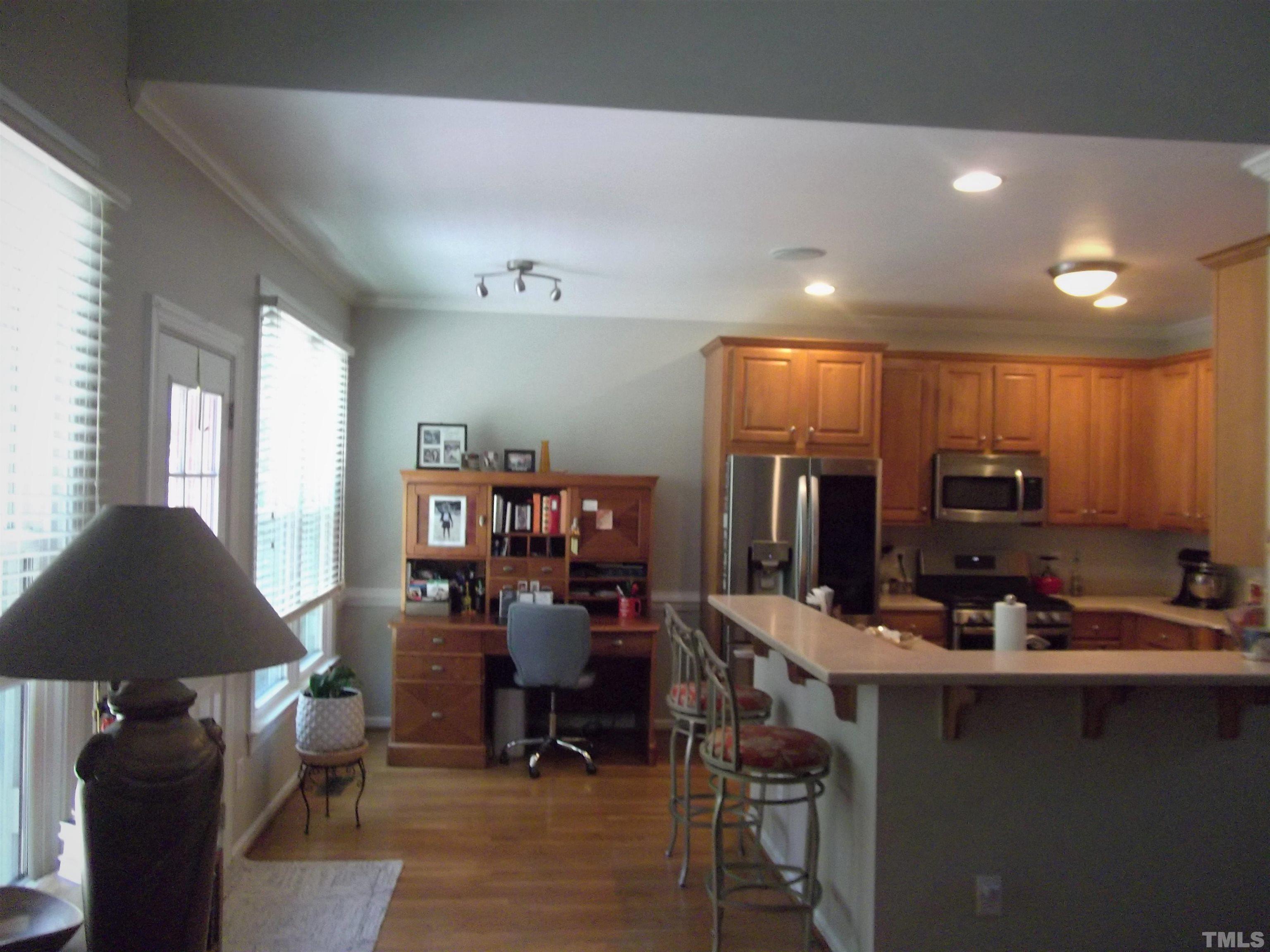 7912 Milltrace Run Raleigh, NC 27615 - Photo 16 of 36 a view of a kitchen with kitchen island granite countertop a table and chairs in it