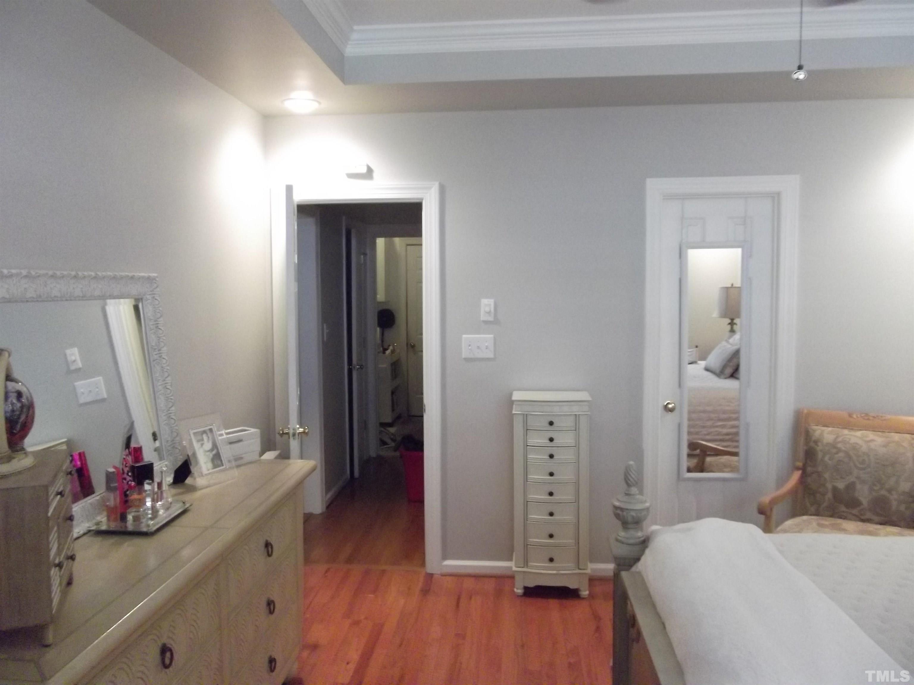 7912 Milltrace Run Raleigh, NC 27615 - Photo 22 of 36 a bedroom with a bed and a wooden floor