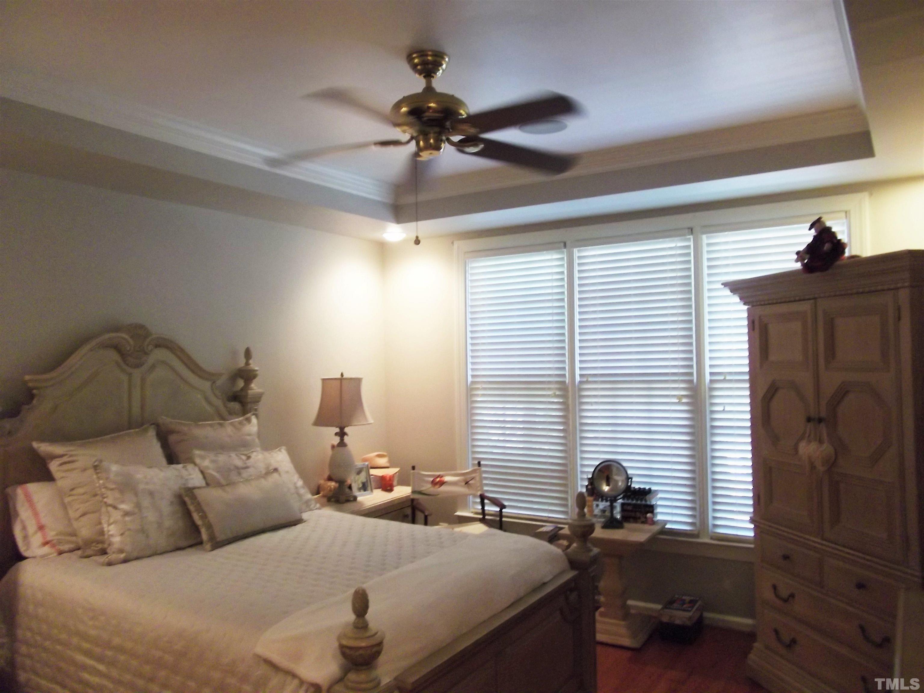 7912 Milltrace Run Raleigh, NC 27615 - Photo 24 of 36 a bedroom with a bed and a chandelier