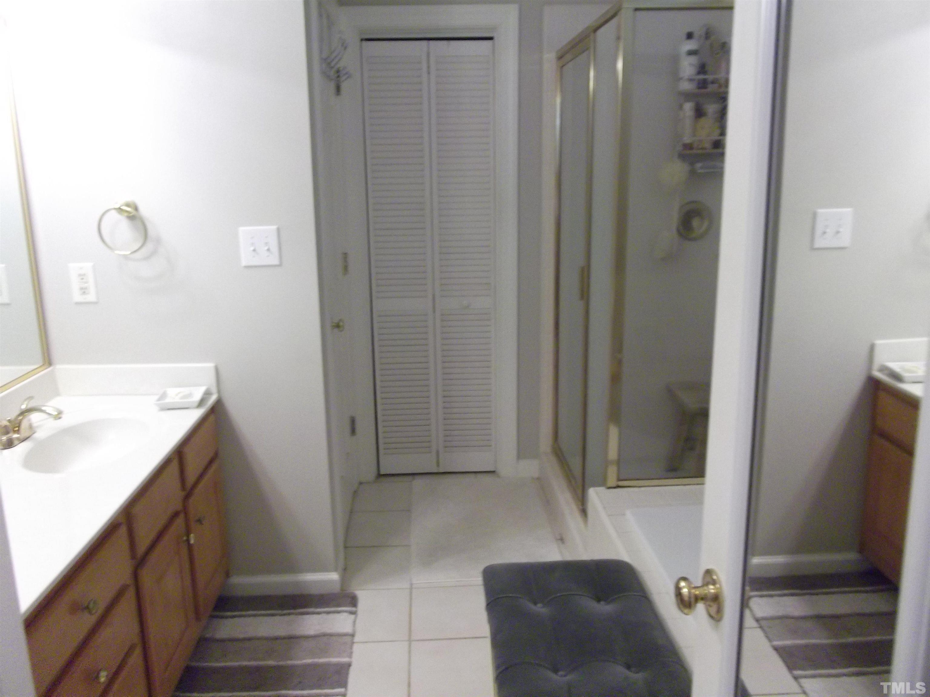 7912 Milltrace Run Raleigh, NC 27615 - Photo 27 of 36 a bathroom with a sink and a mirror