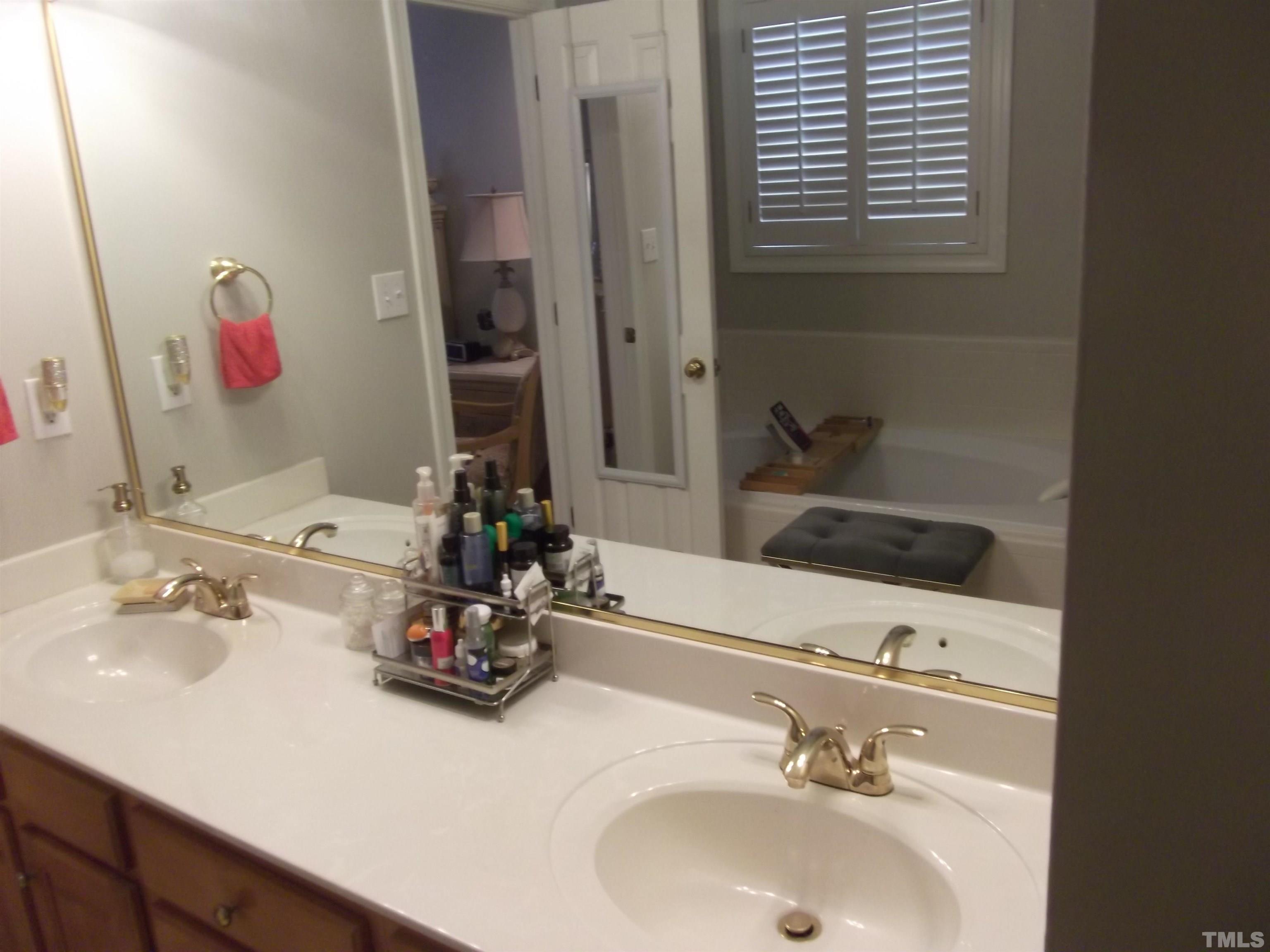 7912 Milltrace Run Raleigh, NC 27615 - Photo 28 of 36 a bathroom with a sink and a mirror