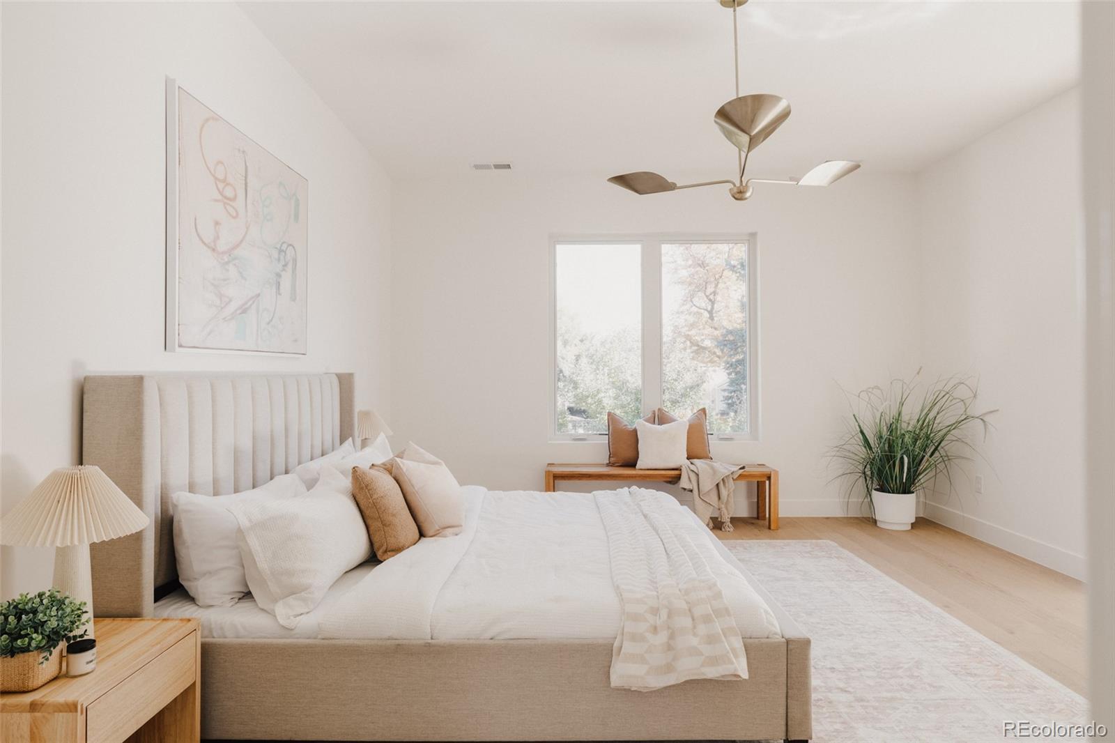 3530 Fenton Street Wheat Ridge, CO 80212 - Photo 21 of 44 a bedroom with a large bed and a chandelier