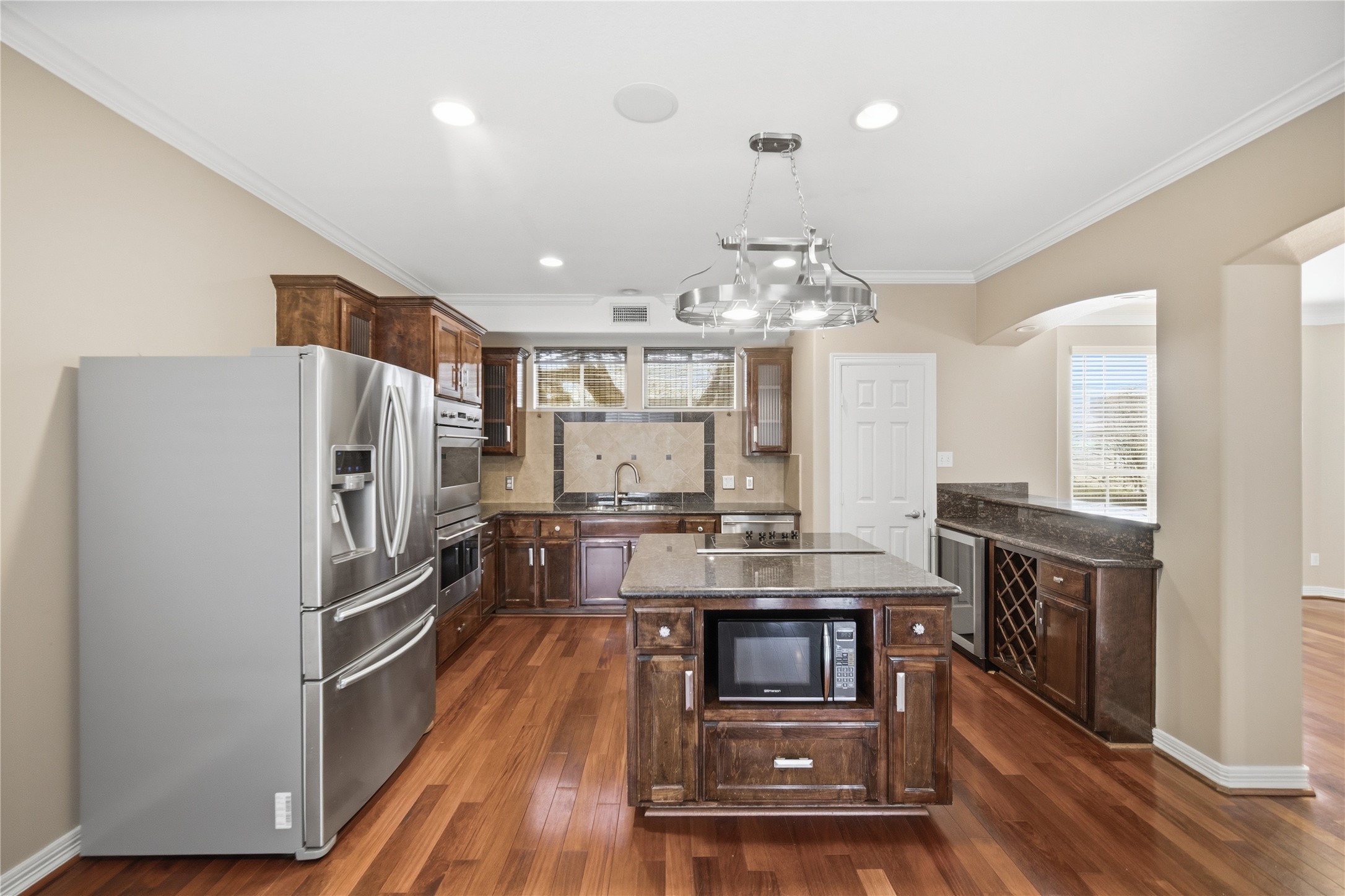 1316 Cleburne Street, Unit B Houston, TX 77004 - Photo 11 of 30 a kitchen with stainless steel appliances a refrigerator a stove a sink dishwasher and a oven with wooden floor