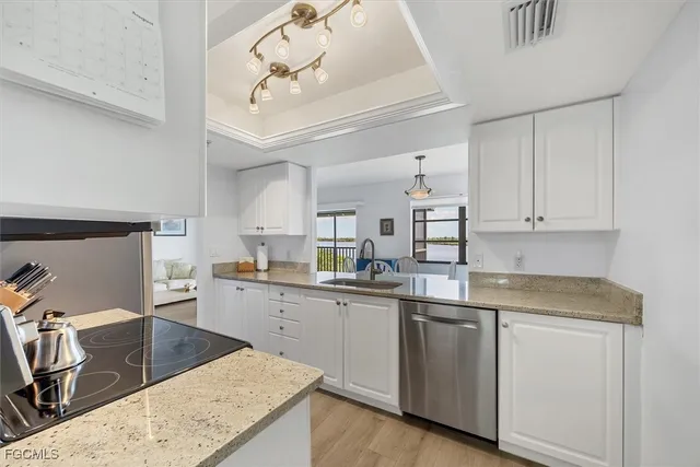 a kitchen with white cabinets sink and stove
