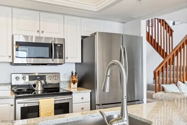 a kitchen with stainless steel appliances granite countertop a refrigerator stove top oven a sink and dishwasher