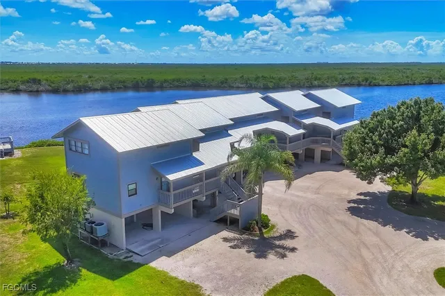 an aerial view of a house with a garden and lake view