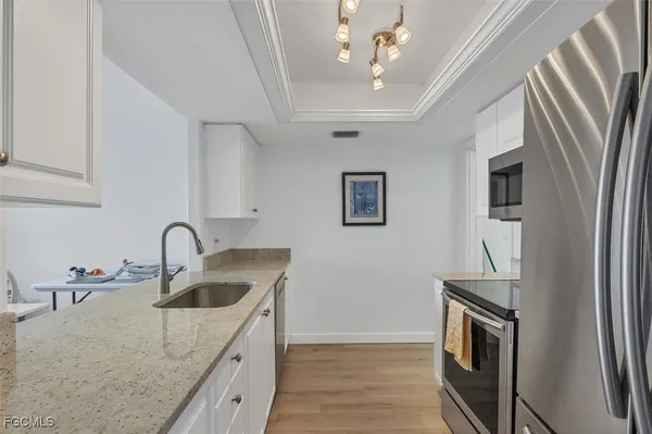 a kitchen with stainless steel appliances granite countertop a sink stove and refrigerator