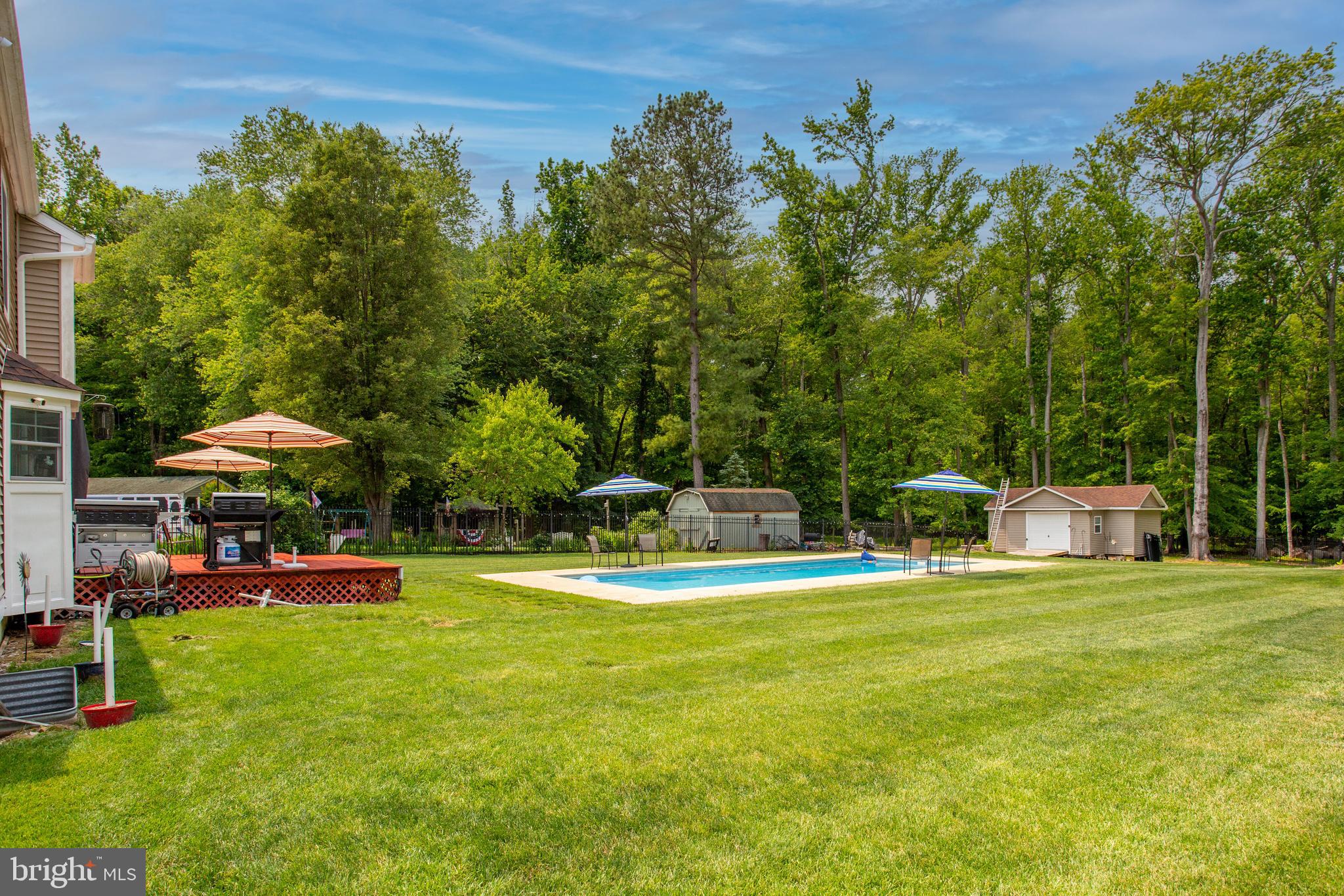 2904 Eutaw Forest Drive Waldorf, MD 20603 - Photo 49 of 59 a view of a swimming pool with lawn chairs under an umbrella