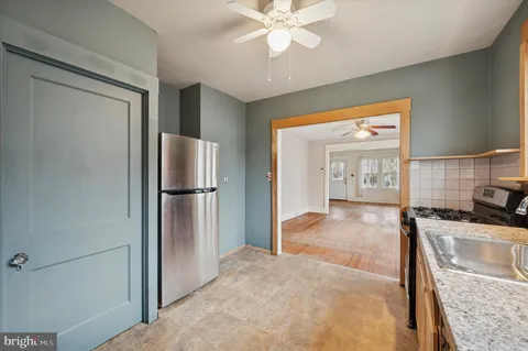 a kitchen with stainless steel appliances granite countertop a refrigerator a sink and a stove