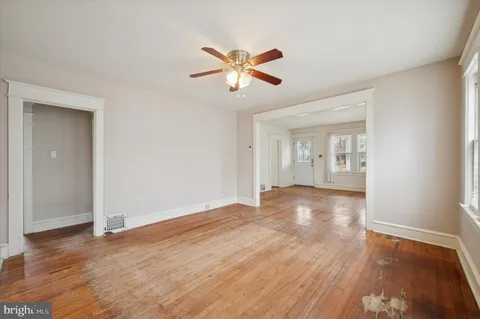 a view of empty room with wooden floor