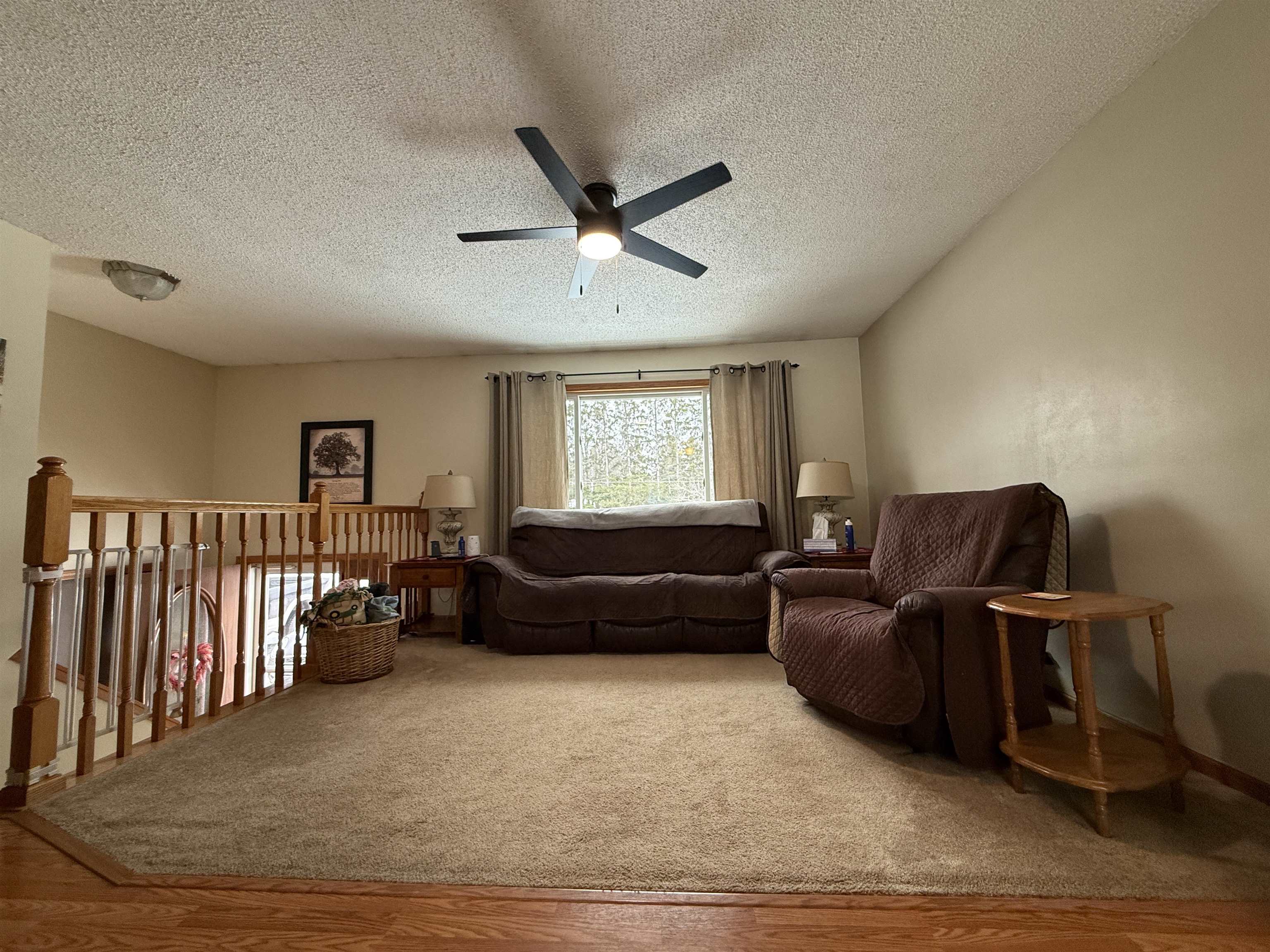 3991 Dillon Road Hibbing, MN 55746 - Photo 15 of 25 Sitting room featuring a textured ceiling, a ceiling fan, wood finished floors, carpet flooring, and an upstairs landing