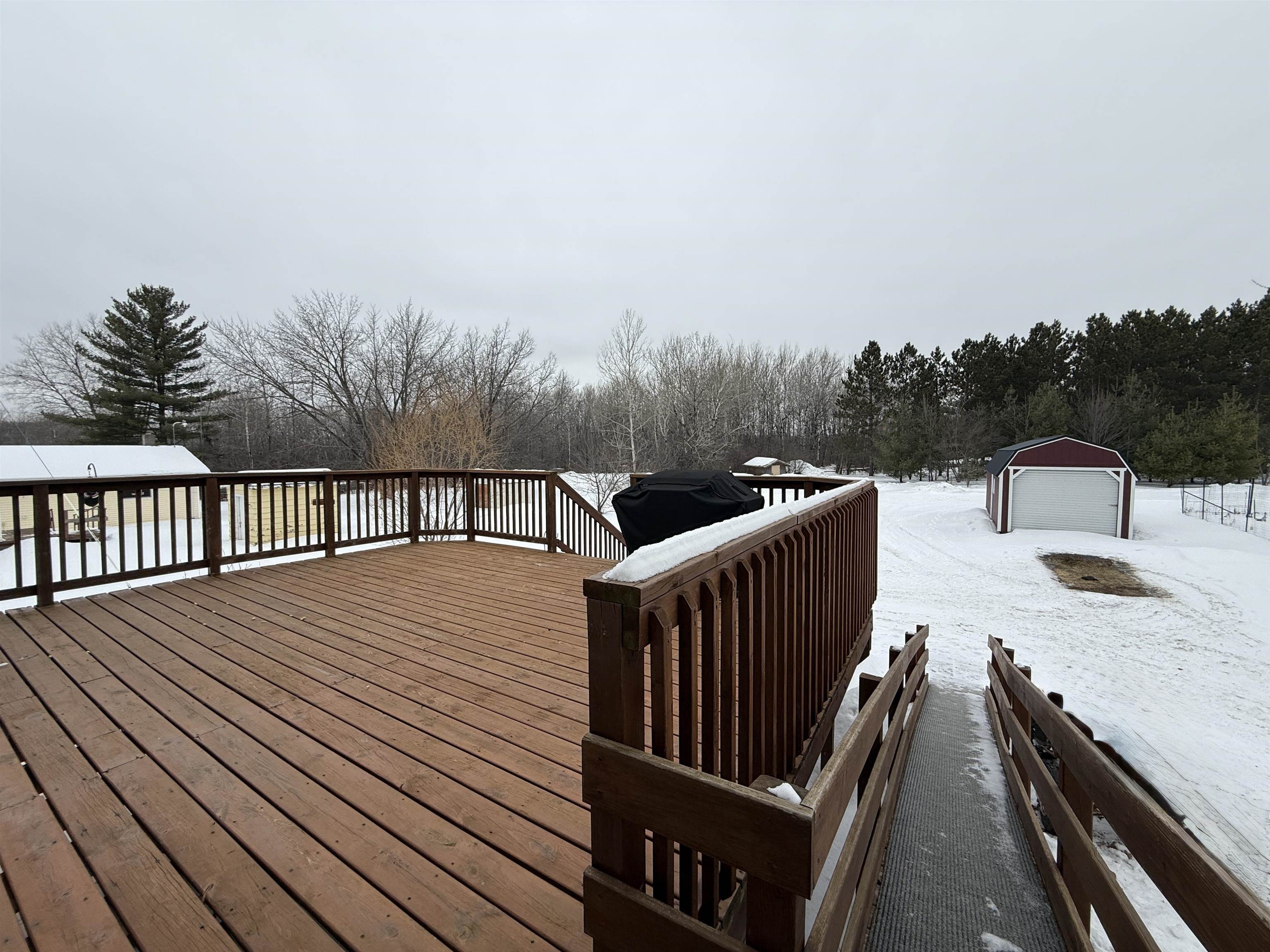 3991 Dillon Road Hibbing, MN 55746 - Photo 8 of 25 Snow covered deck with an outbuilding and a grill