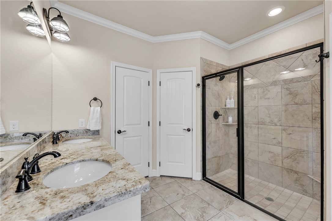 8312 Raintree Drive College Station, TX 77845 - Photo 16 of 30 Dual vanity with granite countertops, undermount sinks, and oil-rubbed bronze fixtures