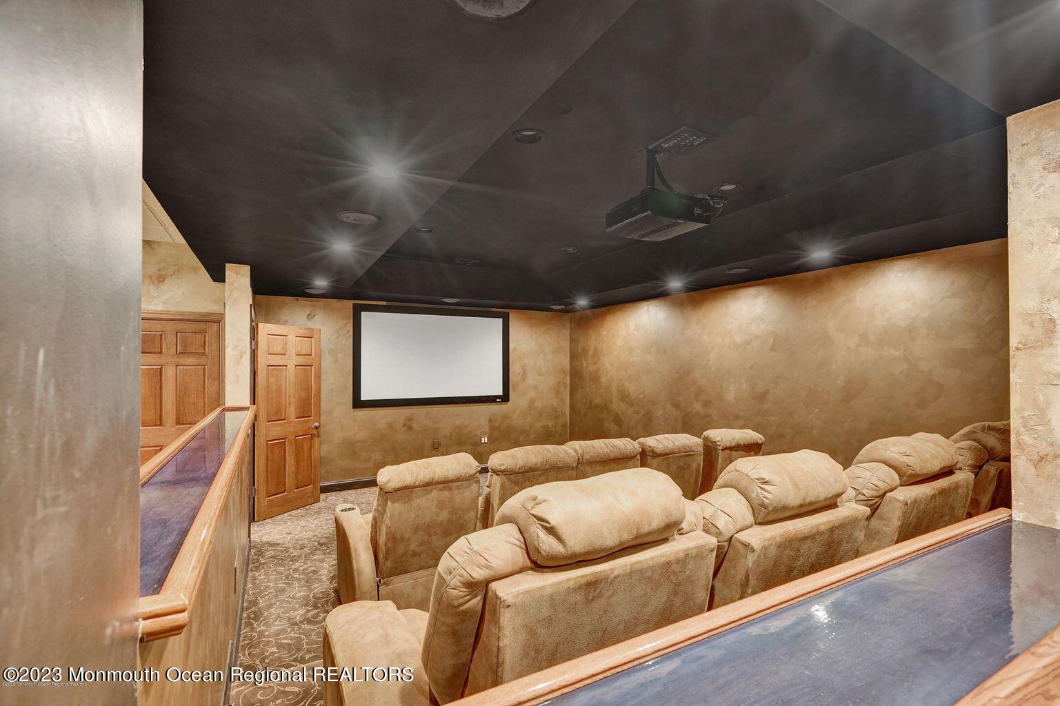 67 Phalanx Road Lincroft, NJ 07738 - Photo 30 of 55 a media room with lots of chairs and a projector screen
