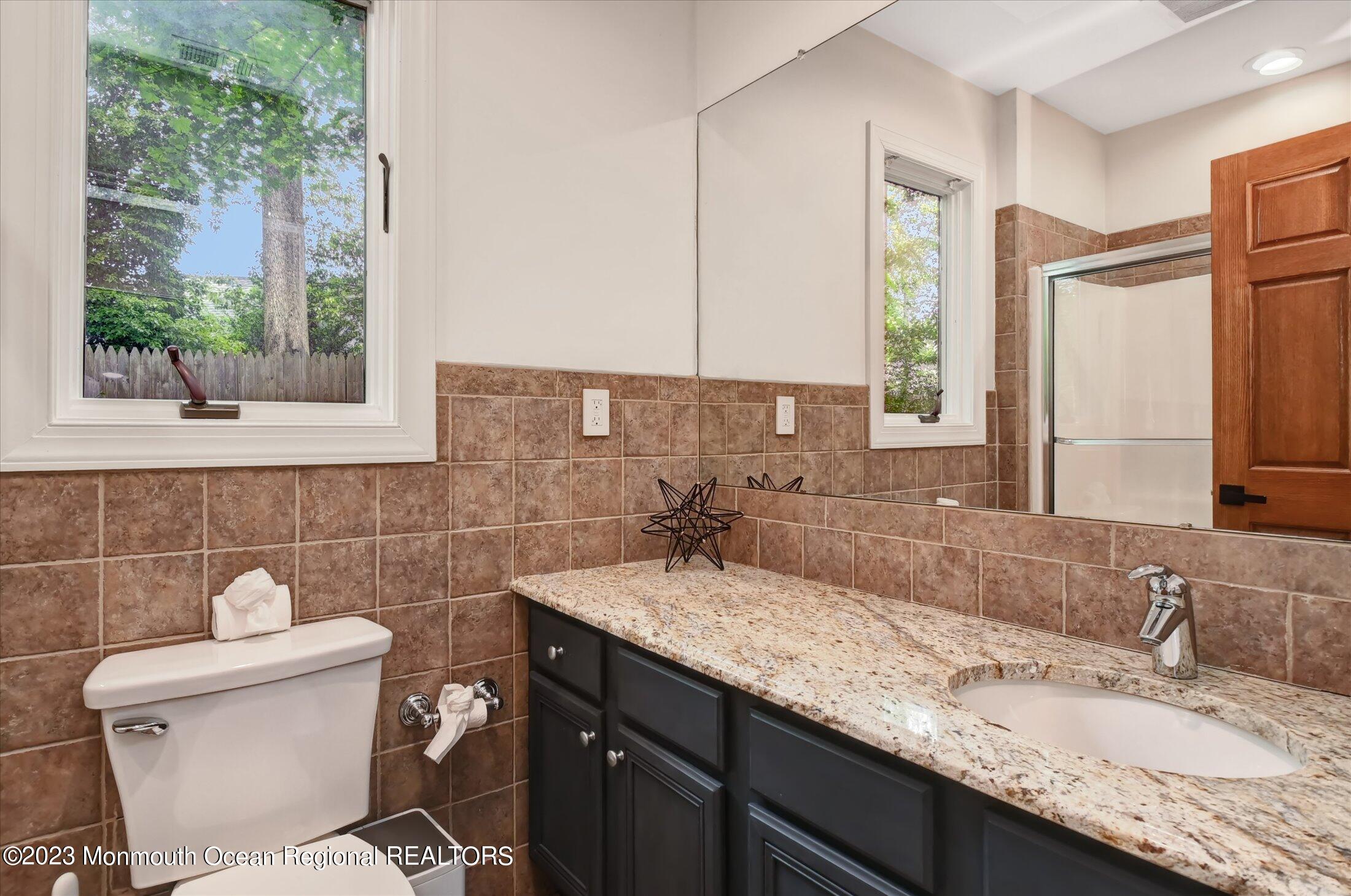 67 Phalanx Road Lincroft, NJ 07738 - Photo 51 of 55 a bathroom with a granite countertop sink a toilet and a mirror