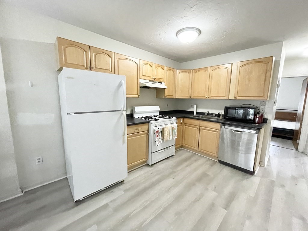 a kitchen with white cabinets and white appliances