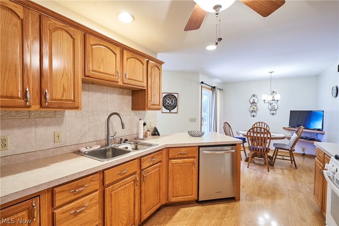 1963 Haines Road Madison, OH 44057 - Photo 14 of 34 Kitchen featuring wood-finish cabinetry, solid surface countertops, and a stainless steel double basin sink with a high-arch faucet