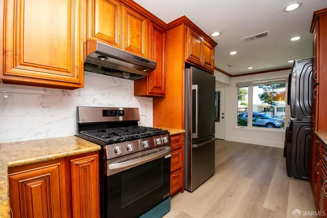 a kitchen with stainless steel appliances granite countertop a stove and a refrigerator