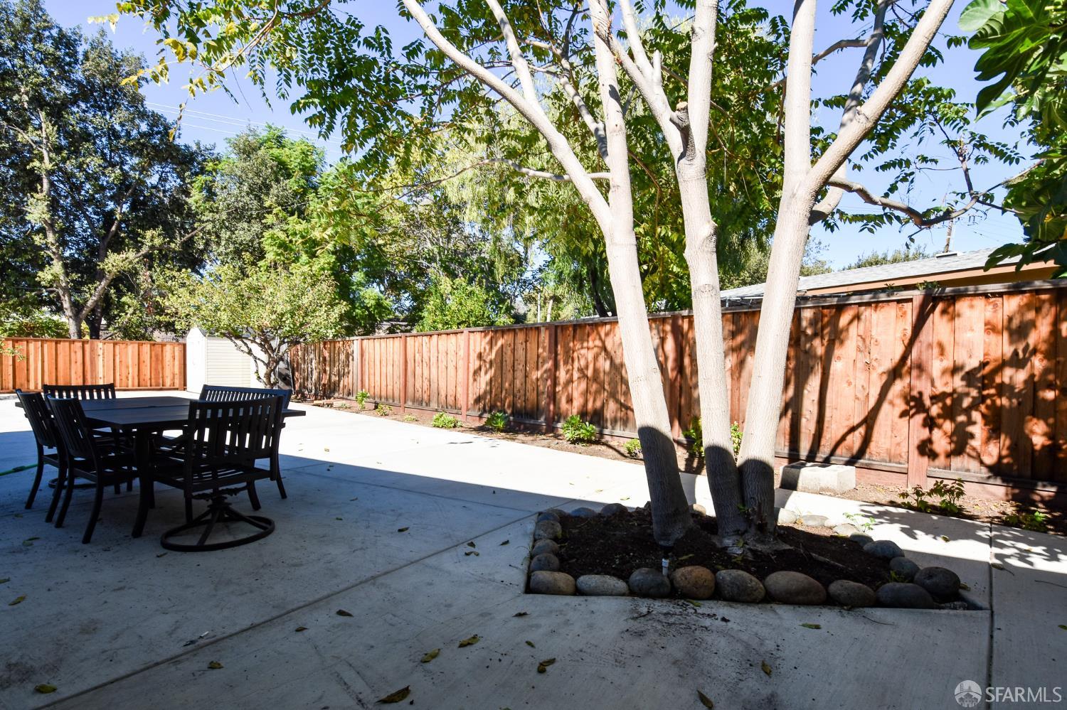 1099 Bradford Drive, Unit A Sunnyvale, CA 94089 - Photo 14 of 16 a view of a patio with table and chairs with wooden fence and plants