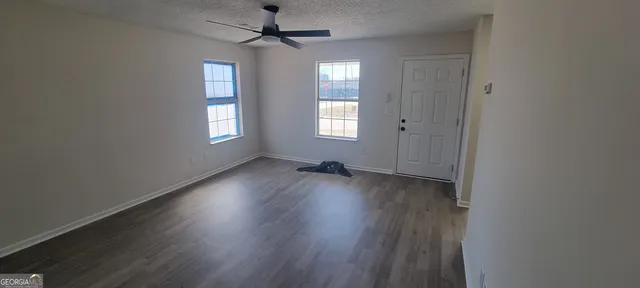 a view of an empty room with wooden floor