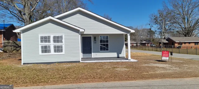 a view of a house with a backyard and garage