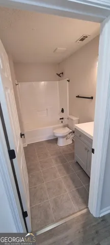 an empty room with wooden floor chandelier fan and windows