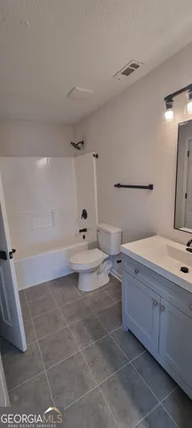 a kitchen with white cabinets stainless steel appliances and wooden floors