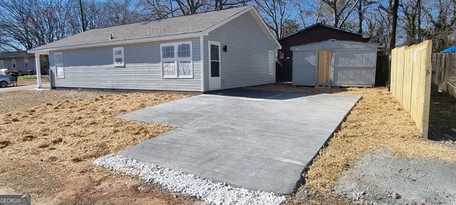 a small house with a small yard and large trees