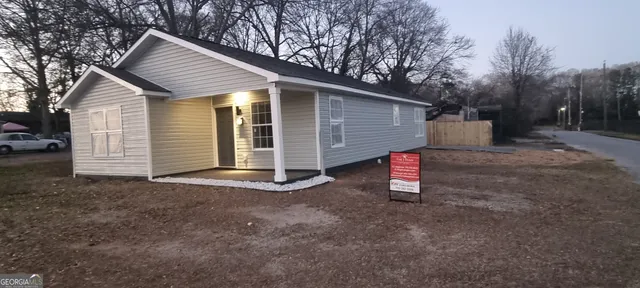a view of backyard of house with large tree