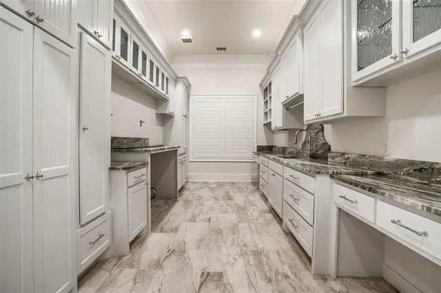 a large kitchen with stainless steel appliances granite countertop a lot of counter space and wooden floors