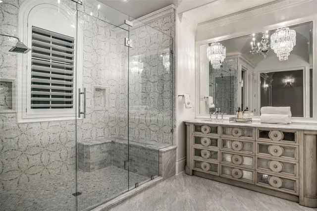 a bathroom with a sink mirror and a shower