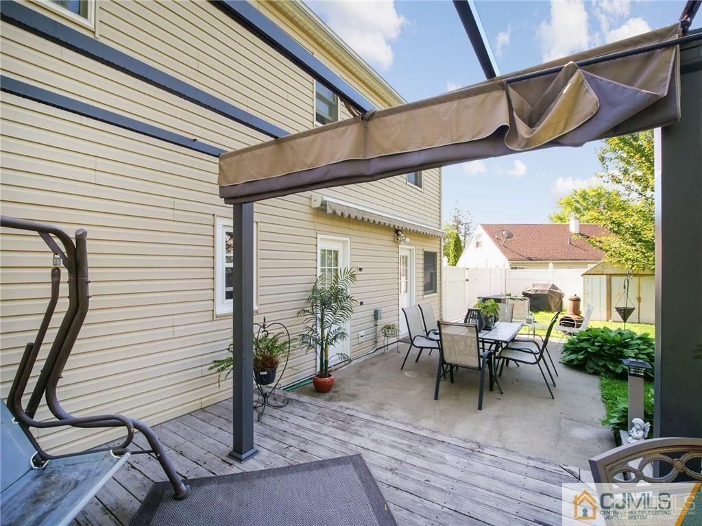 13 Stiles Road Edison, NJ 08817 - Photo 19 of 24 a view of a patio with table and chairs potted plants and wooden floor
