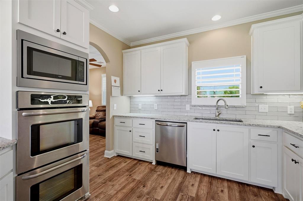 662 Preakness Place Road Van Alstyne, TX 75495 - Photo 11 of 39 a kitchen with granite countertop cabinets stainless steel appliances and wooden floor