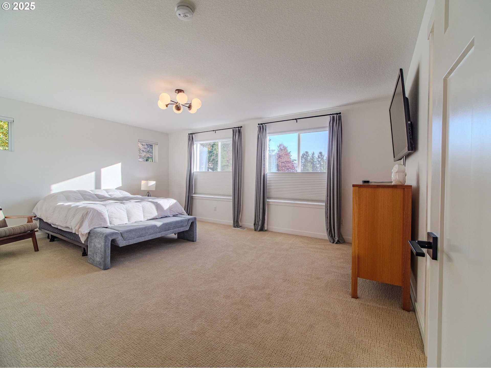 8588 Summit Court Portland, OR 97225 - Photo 15 of 22 a spacious bedroom with a bed and a chandelier