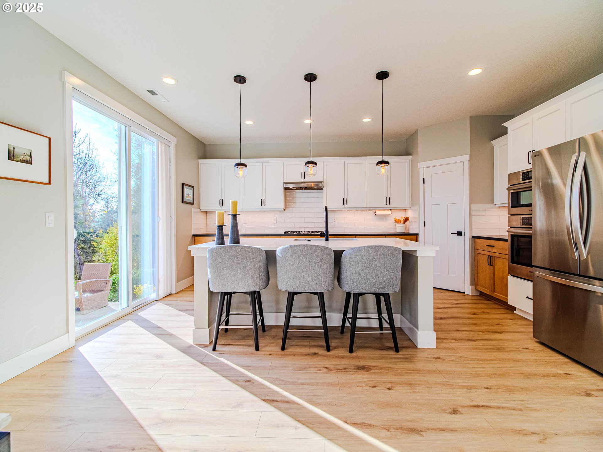 8588 Summit Court Portland, OR 97225 - Photo 5 of 22 a large kitchen with a table chairs refrigerator and microwave