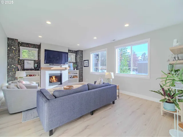 a living room with furniture fireplace and a large window