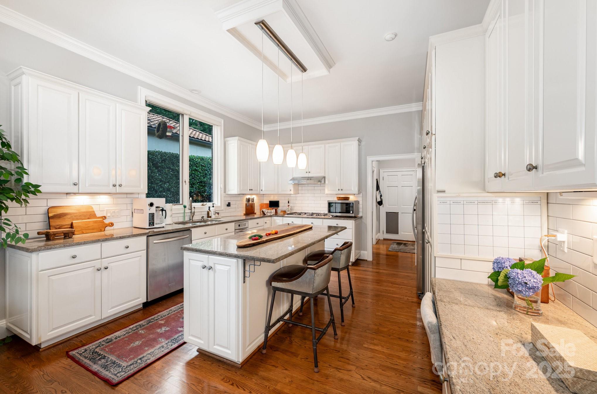 16133 North Point Road Huntersville, NC 28078 - Photo 18 of 48 a kitchen with stainless steel appliances a stove a sink dishwasher and cabinets with wooden floor