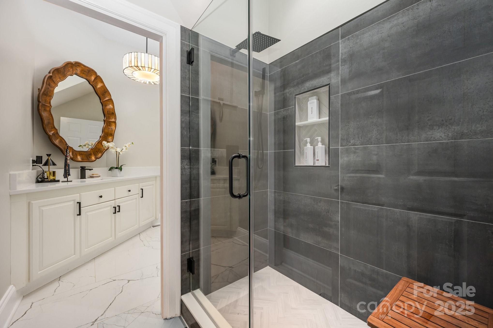 16133 North Point Road Huntersville, NC 28078 - Photo 28 of 48 a bathroom with a granite countertop sink a mirror and shower