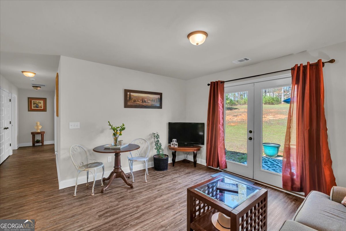 773 Weldon Road Forsyth, GA 31029 - Photo 15 of 37 a living room with furniture a flat screen tv and a floor to ceiling window