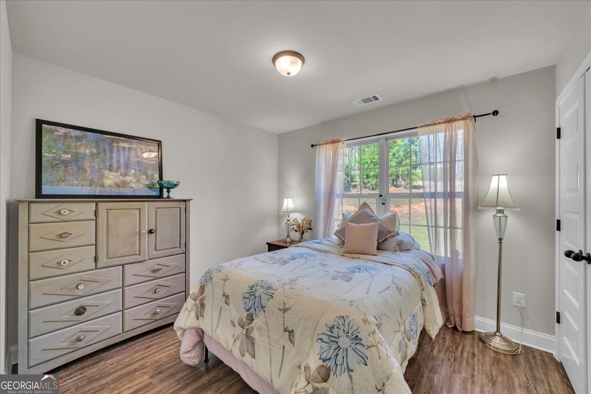 773 Weldon Road Forsyth, GA 31029 - Photo 21 of 37 a bedroom with a bed and wooden floor